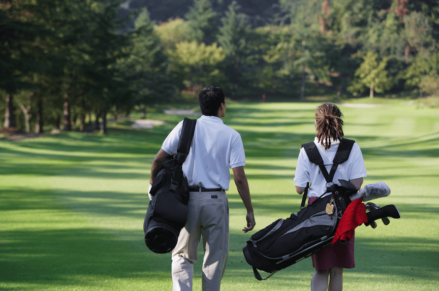 two golfers walking on a fairway